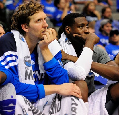 Dirk Nowitzki and Ian Mahinmi watch as the Mavs, champs last season, fall one game from being swept out of the first round.  (US Presswire)