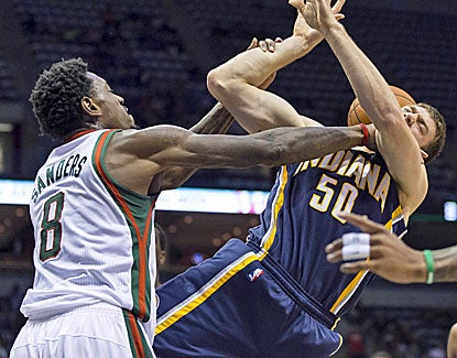 Milwaukee's Larry Sanders roughs up Indiana's Tyler Hansbrough, who scores 17 points in the game. (US Presswire)