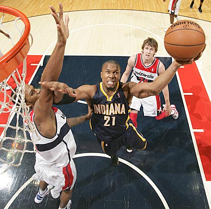 David West, shown driving past Trevor Ariza, gets hot down the stretch to help Indiana keep Washington winless.  (Getty Images)