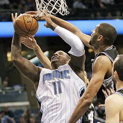 Tim Duncan gets a piece of Glen Davis' shot during the first half, during which San Antonio holds Orlando to 41 points.  (AP)