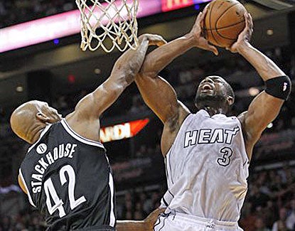 Dwyane Wade is in vintage form against the Nets, fighting to get to the basket against Brooklyn's Jerry Stackhouse. (AP)