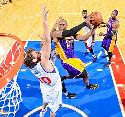 Kobe Bryant slashes his way past Spencer Hawes and the 76ers. He scores at least 30 points for the sixth consecutive game.  (AP)