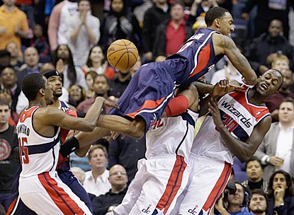 Atlanta's Jeff Teague nearly wipes out Washington's Nene (42) and Earl Barron (30) and earns a charging foul.  (Getty Images)