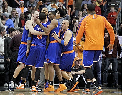 Knicks players huddle around J.R. Smith after he hits a 21-footer at the buzzer to beat the Suns. (AP)