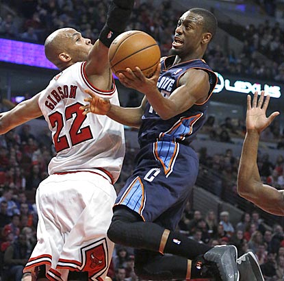 Kemba Walker, who winds up leading Charlotte with 18 points, drives around Chicago forward Taj Gibson during the first half.  (AP)