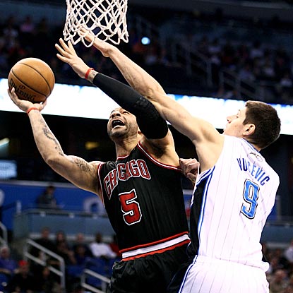 Carlos Boozer attempts to get off a shot against Orlando's Nikola Vucevic during the first quarter. (US Presswire)