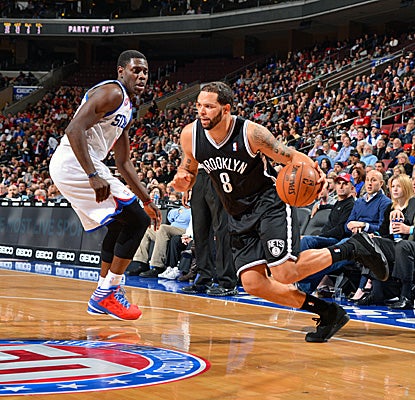 Deron Williams, who scores 22 points for Brooklyn, drives against Philadelphia's Jrue Holiday in the Nets' win. (Getty Images)