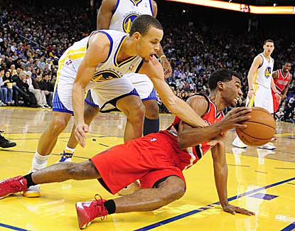 Golden State's Stephen Curry, who finishes with 22 points, battles with Portland's Ronnie Price for a loose ball.  (US Presswire)
