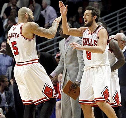 Carlos Boozer (left) is among the first to congratulate Marco Belinelli for making what proves to be the winning shot.  (AP)