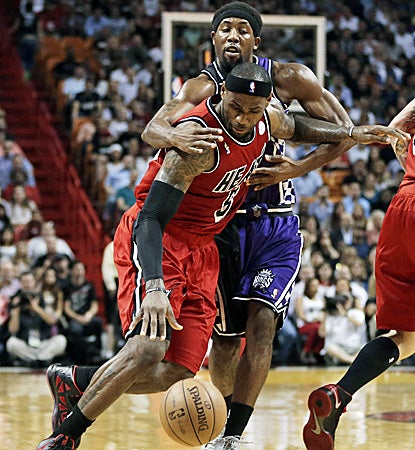 Miami's LeBron James, who scores 40 points and registers a career-high 16 assists, is fouled by Sacramento's John Salmons. (AP)