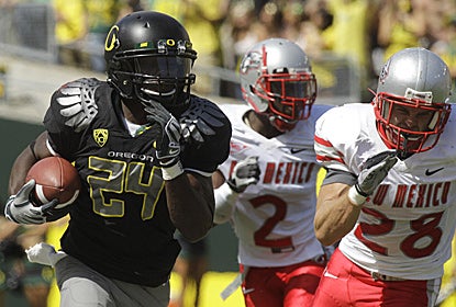 Kenjon Barner (24) runs past New Mexico's Emmanuel McPherson (2) and Bubba Forrest for a score.  (AP)