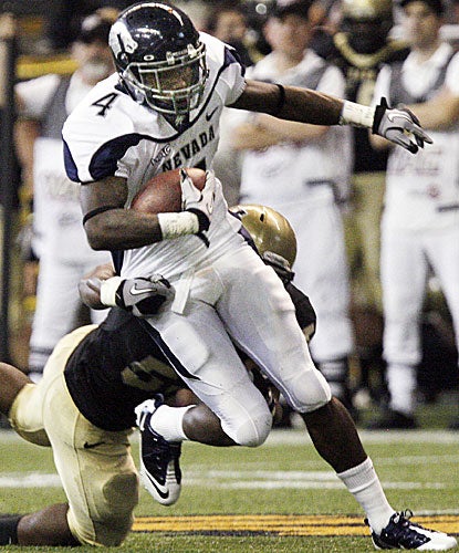 Nevada receiver Brandon Wimberly breaks a tackle by Idaho linebacker Tre'Shawn Robinson.  (AP)