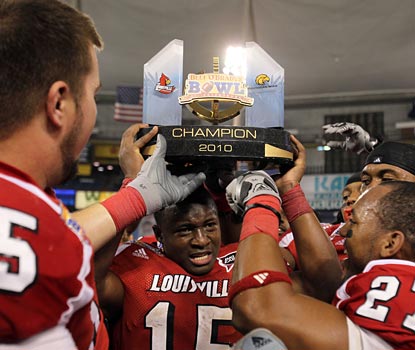Cards RB Bilal Powell is the center of attention as he lifts the trophy he helps earn with 75 yards rushing.  (US Presswire)