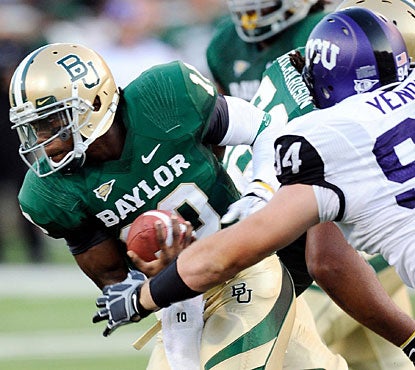 Robert Griffin, who connects for five touchdowns, avoids a rush by TCU defensive tackle D.J. Yendrey. (US Presswire)