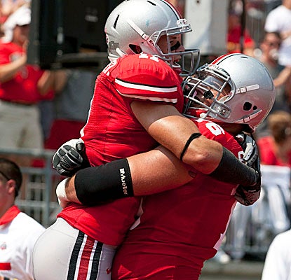 TE Jake Stoneburner gets a hug from OL J.B. Shugarts after the second of his three TDs in Ohio State's win. (US Presswire)