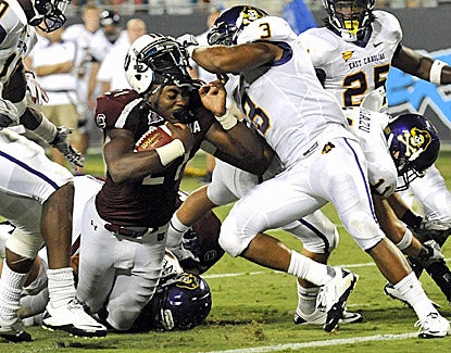 South Carolina's Marcus Lattimore gets his helmet ripped off while trying to bull his way forward for extra yards. (US Presswire)