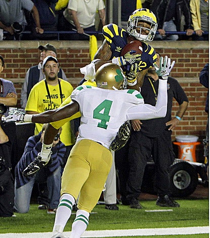 Michigan's Roy Roundtree catches the game-winning touchdown pass over Notre Dame's Gary Gray. (AP)