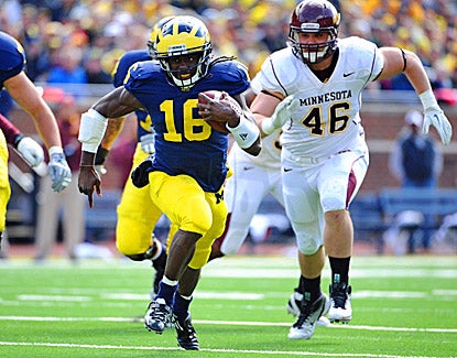 Denard Robinson runs for extra yards against Minnesota. He throws two touchdown passes and runs for another in the 58-0 win. (US Presswire)