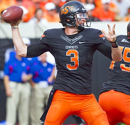 The Cowboys' Brandon Weeden lights up the Jayhawks' defense for 288 passing yards and five touchdowns. (US Presswire)