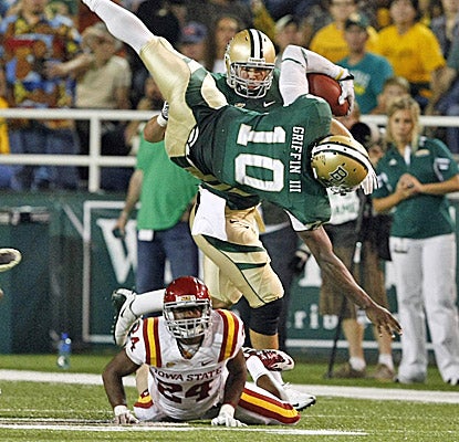 Baylor quarterback Robert Griffin III dives over Iowa State defensive back Durrell Givens. He runs for 107 yards in the win. (AP)