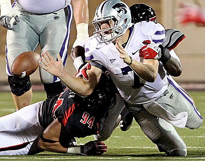 Collin Klein accounts for four touchdowns, but fumbles while being tackled by Texas Tech's Leon Mackey and Scott Smith (94). (AP)