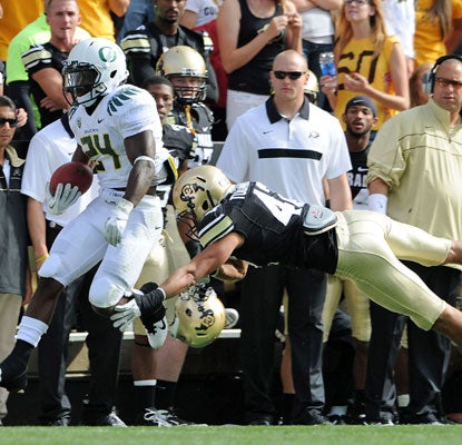 Oregon's Kenjon Barner eludes a Colorado defender to finish his 84-yard touchdown sprint in the first quarter.   (US Presswire)
