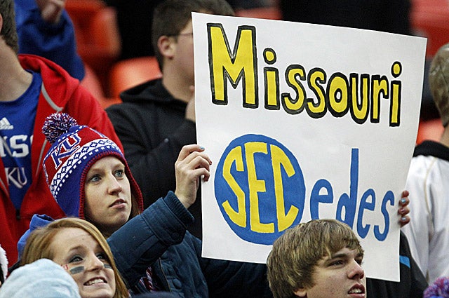 A Kansas fan holds up a sign about Missouri leaving the Big 12 conference for the SEC. (AP)