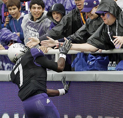 Horned Frog Greg McCoy leaps to the fans following his 99-yard kickoff return for a TD in the second quarter. (AP)