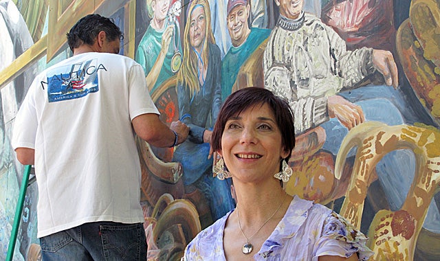 Ann Van Kuren, one of the 12 jurors who convicted Jerry Sandusky, poses next to the mural. (AP)
