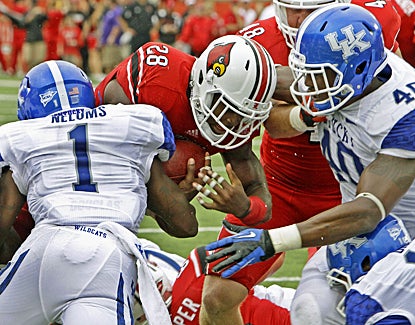 Louisville's Jeremy Wright (28) muscles through Kentucky's defense for three touchdowns. (AP)