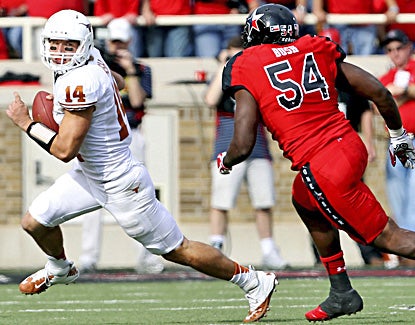 Texas' David Ash runs from Texas Tech's Dartwan Bush while passing for three touchdowns and 264 yards. (AP)