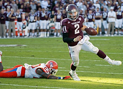 Johnny Manziel, who tosses three touchdowns, runs in for one of his two rushing scores against Sam Houston State. (AP)