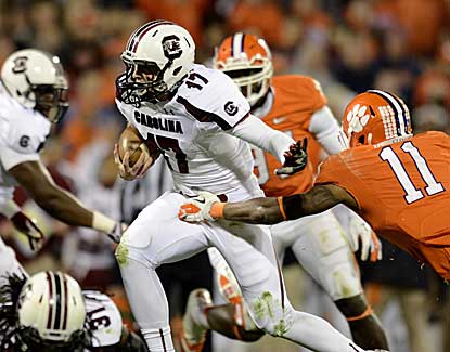 South Carolina quarterback Dylan Thompson escapes the grasp of Clemson's Travis Blanks. (AP)