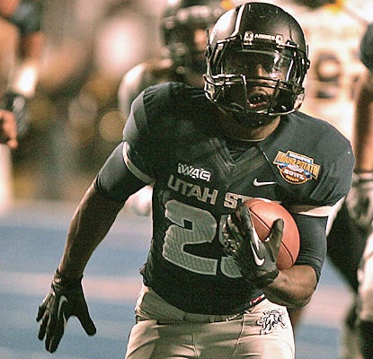 Game MVP Kerwynn Williams runs for 235 yards and three TDs to help Utah State win its first bowl game since 1993. (AP)