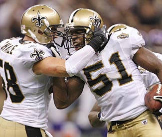 Jonathan Vilma (right) plays a part in the stout defensive effort with an interception. (US Presswire)