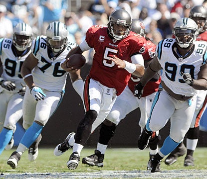 Josh Freeman eludes would-be tacklers, finishing with 43 yards on four carries. He also adds two TDs through the air. (AP)