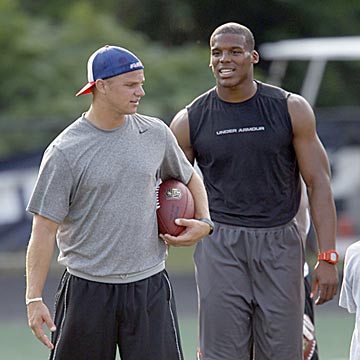 Incumbent Panthers starting quarterback Jimmy Clausen converses with his presumptive successor Cam Newton. (AP)