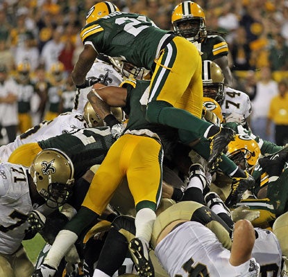 The Packers defense swarms to the ball to stuff Saints rookie Mark Ingram at the 1-yard line with no time left on the clock.  (US Presswire)