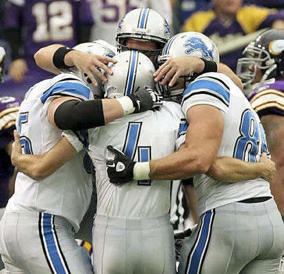 The Lions hail kicker Jason Hanson (4), who converts four field goals, including the game-winner in overtime.  (AP)