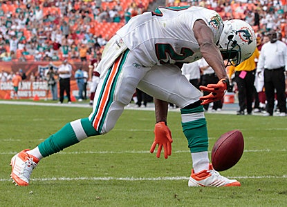Reggie Bush spikes the ball after one of his two rushing touchdowns on the day.  The Dolphins finally snap their home schneid. (Getty Images)