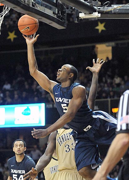 Xavier's Dezmine Wells attempts an acrobatic shot around Vanderbilt forward Steve Tchiengang (33) during overtime.  (US Presswire)