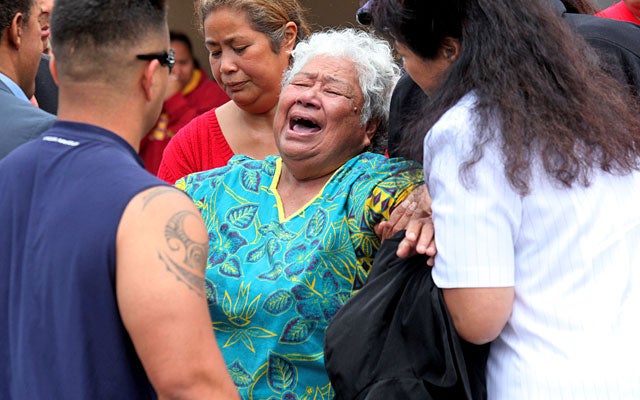 Luisa Seau is consoled by family and friends Wednesday after learning of her son's suicide. (Getty Images)