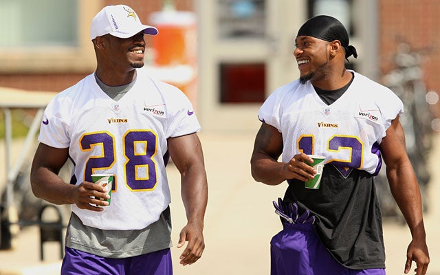 Adrian Peterson walks to practice with Percy Harvin, but doesn't get to participate. (AP)