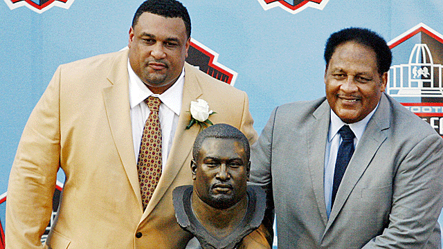 Willie Roaf stands next to his Hall of Fame bust with his father, Clifton. (US Presswire)