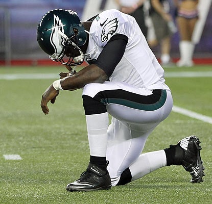 A hard shot to the ribs knocks Michael Vick out of the exhibition against the Pats. X-rays come back negative. (Getty Images)