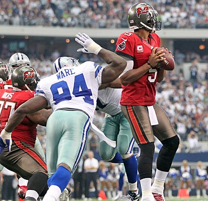 Josh Freeman doesn't know it, but Dallas' DeMarcus Ware is about to strip the ball away from behind.  (US Presswire)