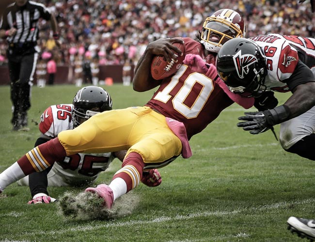 Robert Griffin III is hit by Falcons Sean Weatherspoon and Jonathan Babineaux. (AP) 