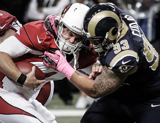 Kevin Kolb is sacked Rams DT Jermelle Cudjo, who was flagged for unnecessary roughness. (AP) 