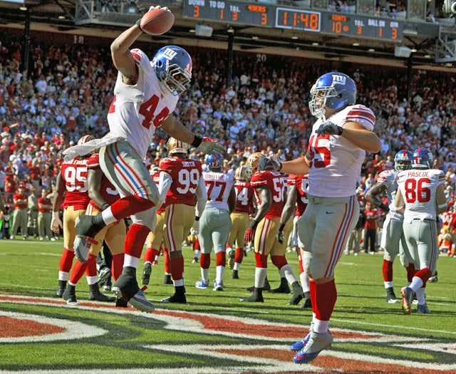 Ahmad Bradshaw (left), who rushes for 116 yards against the 49ers, scores a touchdown. (Getty Images)