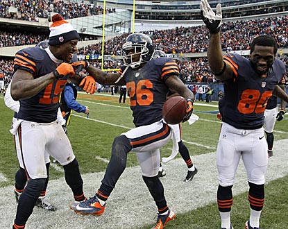 Teammates Brandon Marshall (15) and Earl Bennett (80) help cornerback Tim Jennings (26) celebrate his pick-six.  (AP)